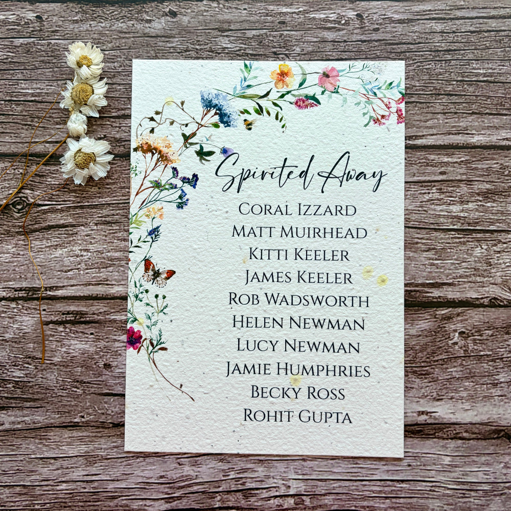 plantable seed paper seating plan for wedding with a butterfly garden on a wooden background