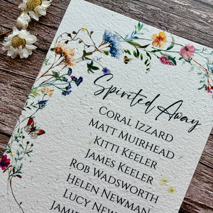 plantable seed paper seating plan cards with a wildflower meadow on a wooden background