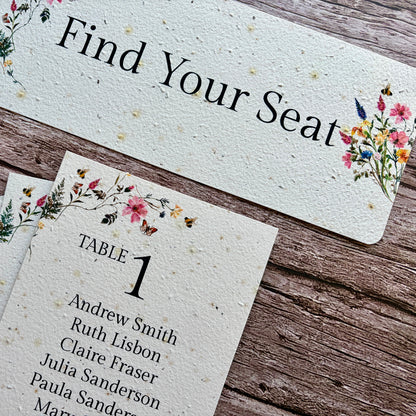 Plantable seating arrangement cards with floral designs on a wooden surface