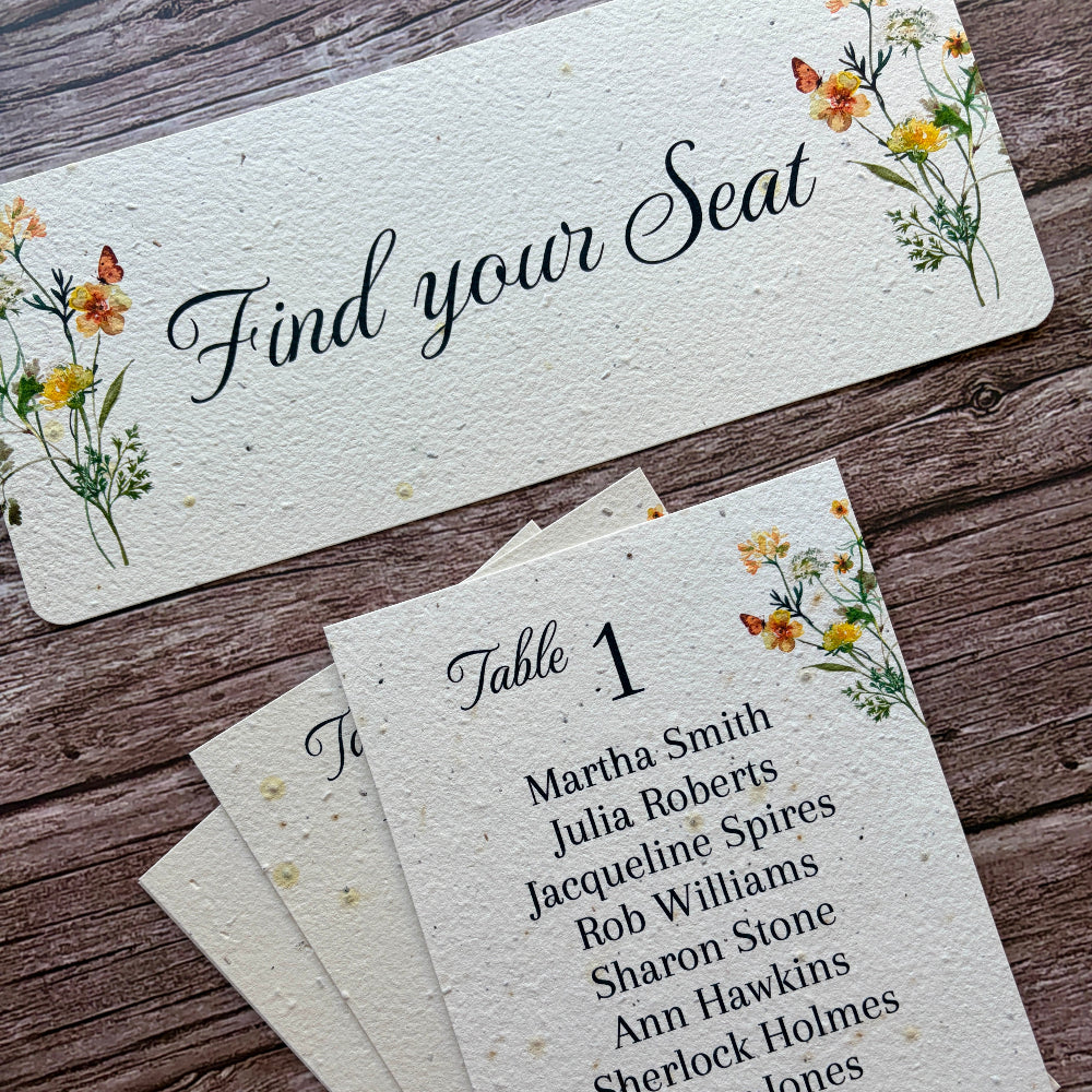 Set of table seating cards with floral designs on a wooden surface made of seed paper with yellow flowers