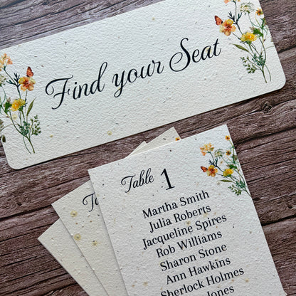 Set of table seating cards with floral designs on a wooden surface made of seed paper with yellow flowers