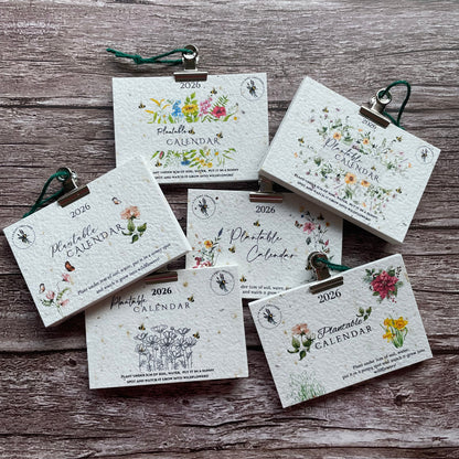 Set of small floral seed paper calendars on a wooden surface
