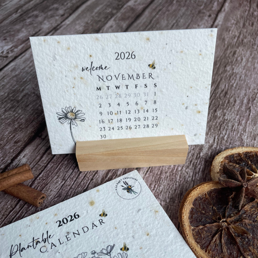 Seed paper calendar with plantable design on a wooden surface with dried oranges and cinnamon sticks.