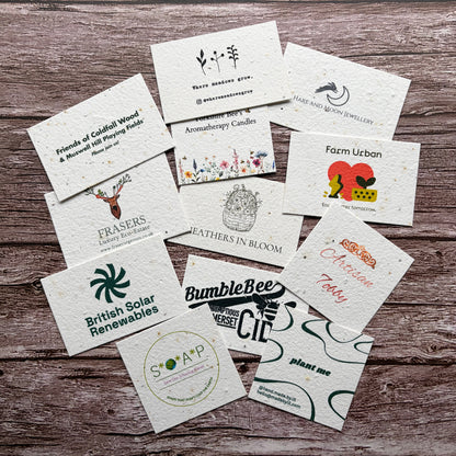 Collection of various plantable business cards on a wooden surface
