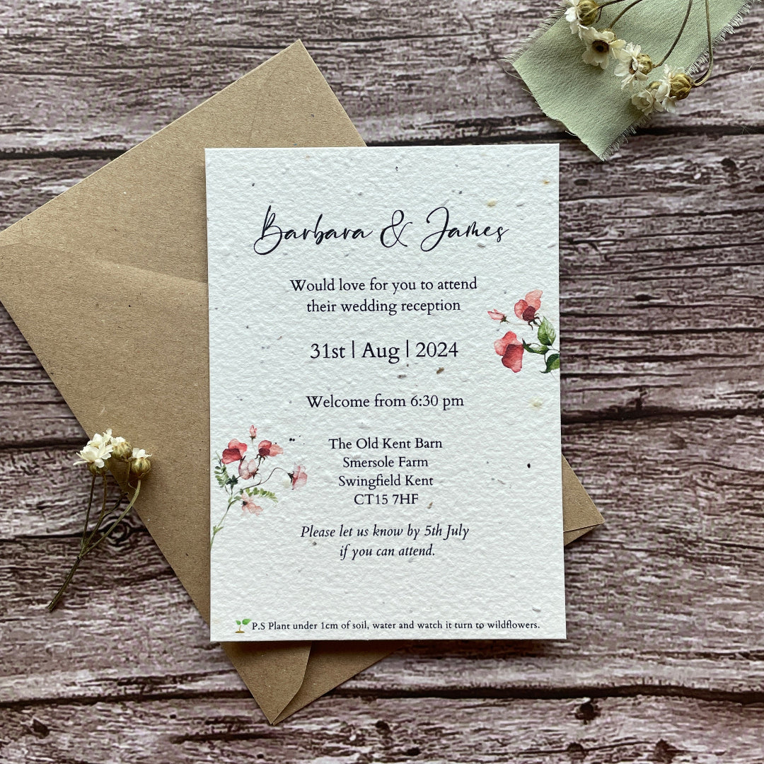 Wedding reception invitation card with floral design on a wooden surface