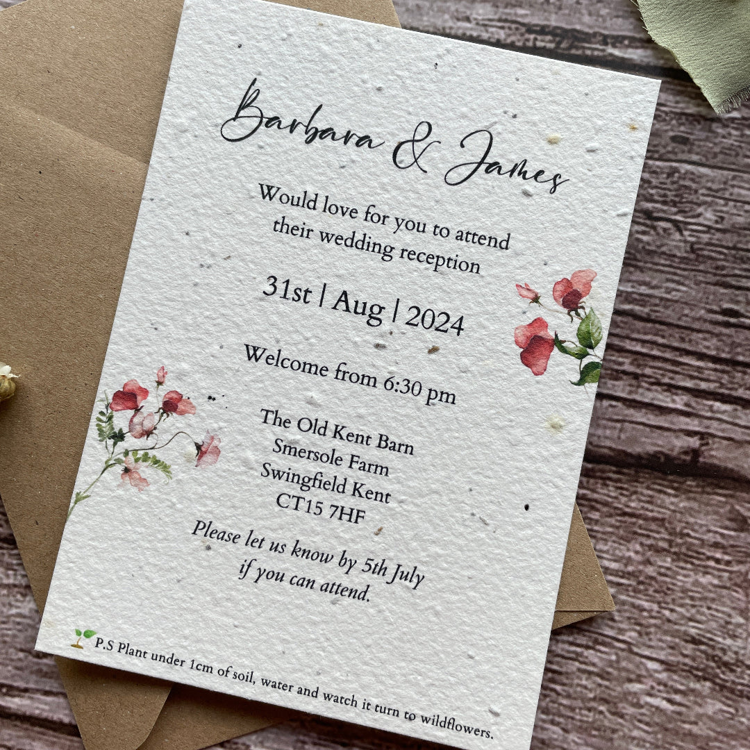 Seed Paper Evening Wedding invitation card with floral designs on a wooden surface