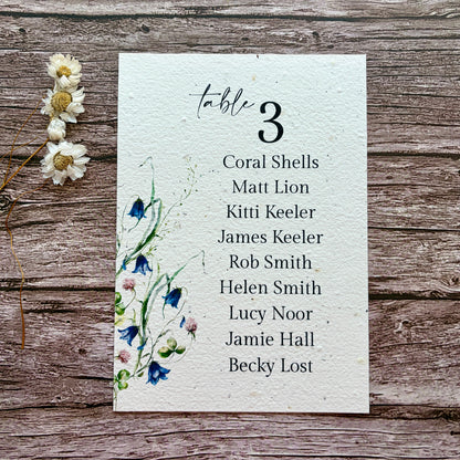 plantable wedding seating plan with lovers and bluebells design on a wooden background
