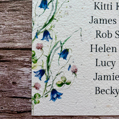 plantable seed paper seating plan for wedding with bluebells design on a wooden background