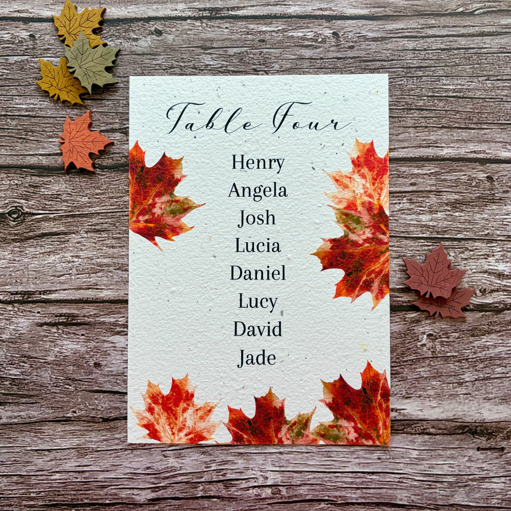 plantable wedding seed paper seating plan cards with maple leaves on a wooden background