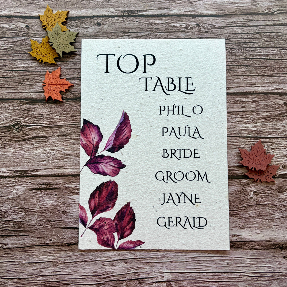 plantable seating plan cards with purple autumn leaves on a wooden background