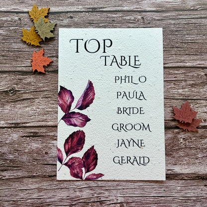plantable seating plan cards with purple autumn leaves on a wooden background