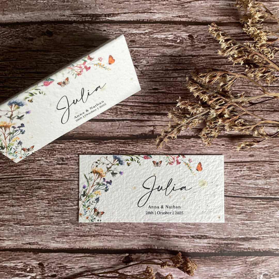 Floral-themed seed paper place card on a wooden surface with butterfly design