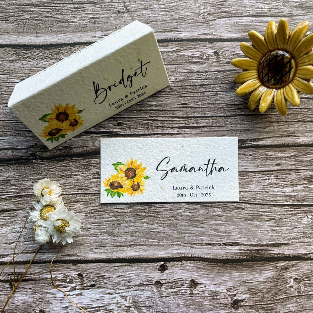 plantable seed paper wedding guest place cards in sunflower theme, showing flat and standing views on wooden background, eco-friendly