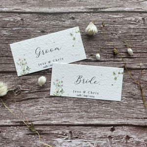 plantable seed paper wedding guest place cards in spring green theme, showing an flat angled view, floral design on wooden background.