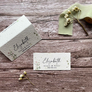 plantable seed paper wedding guest place cards in spring green theme, showing flat and standing views, floral design on wooden background.