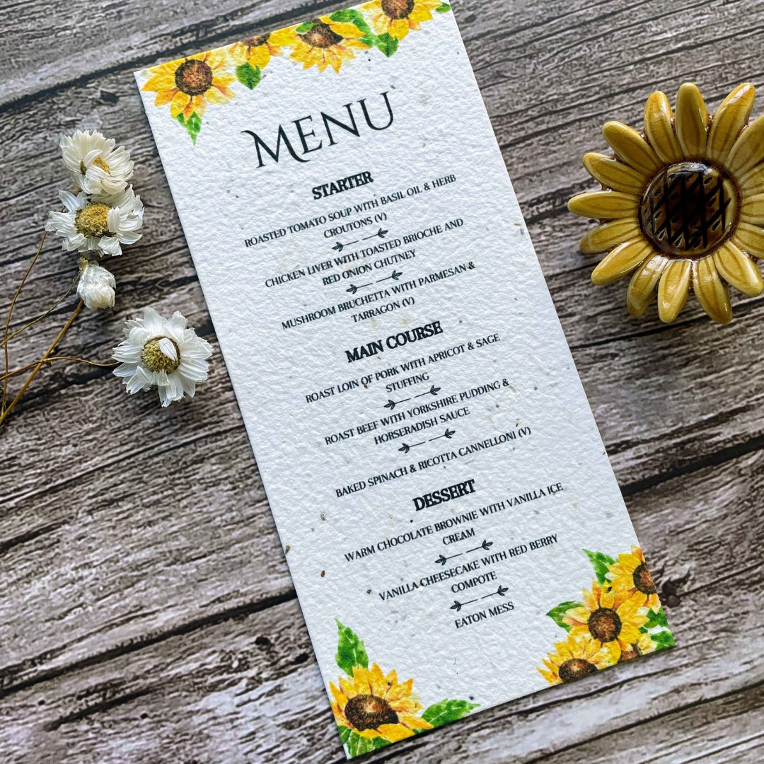 plantable seed paper wedding menu card in sunflower theme, close-up angled front view, floral design on wooden background