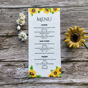 plantable seed paper wedding menu card in sunflower theme, close-up front view, floral design on wooden background, eco-friendly