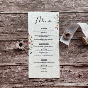 plantable seed paper wedding menu cards with wildflower design on a wooden surface