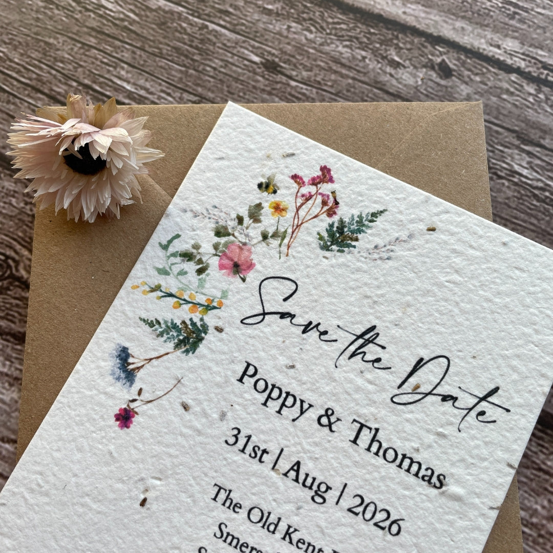 plantable seed paper wedding save the date cards with wildflower meadow theme, angled view with brown kraft envelope, eco-friendly wedding stationery