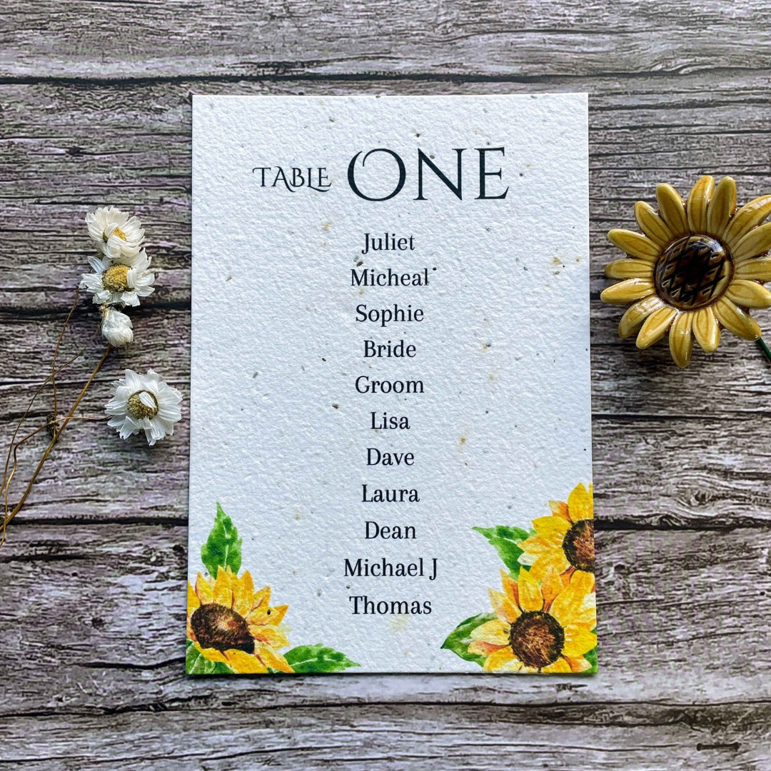 plantable seed paper wedding table seating plan in sunflowers theme, showing front view, floral design on wooden background, eco-friendly