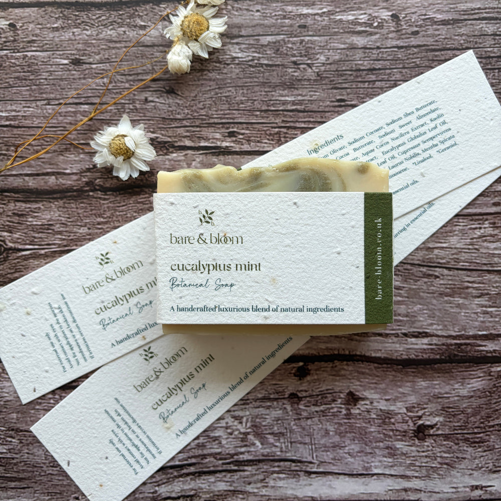 Bar of soap with a plantable label on a wooden surface with dried flowers