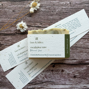 Bar of soap with a plantable label on a wooden surface with dried flowers