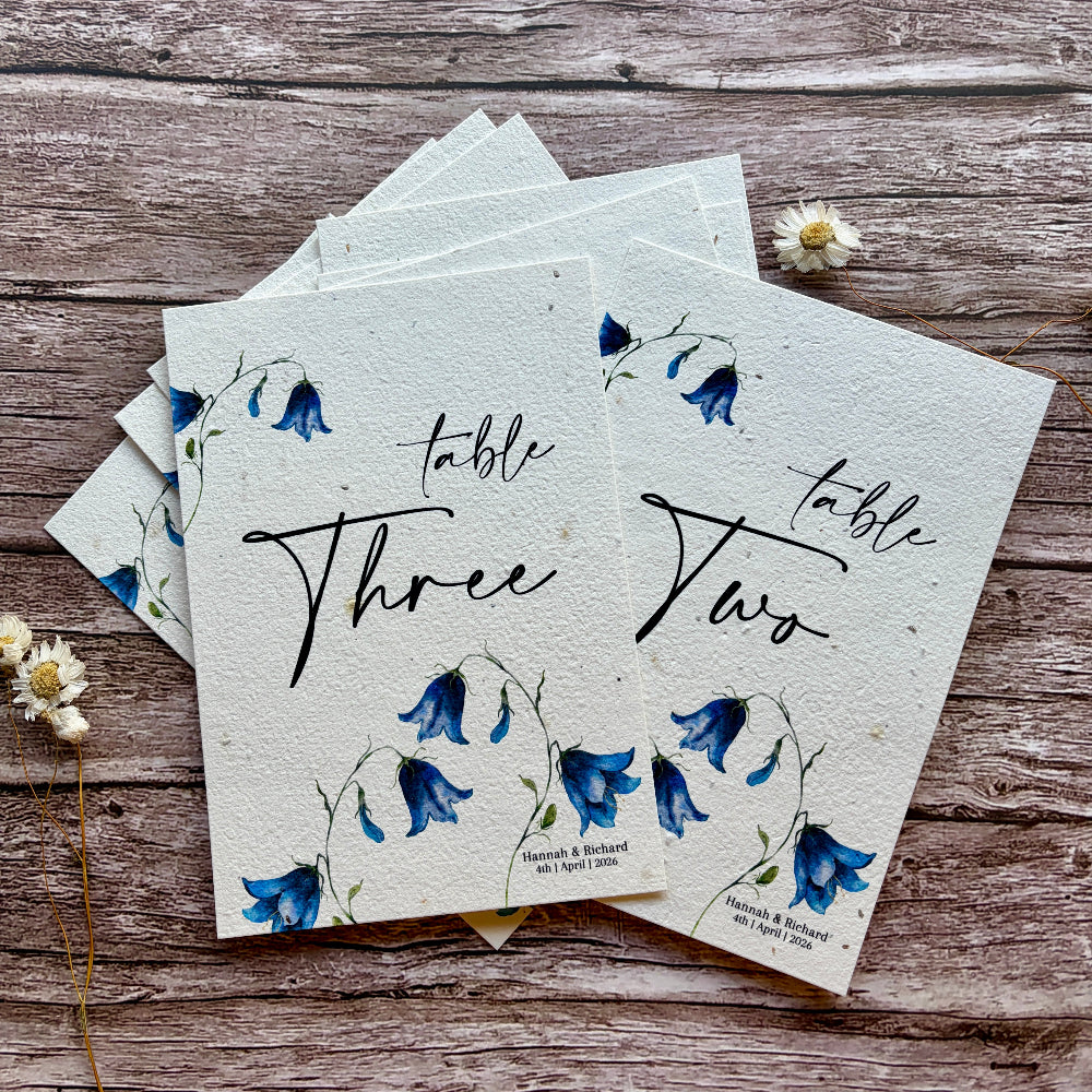 plantable wedding table numbers on a wooden surface with bluebells