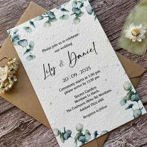 plantable main wedding invites with eucalyptus design on a wooden background