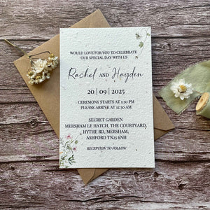 personalised plantable wedding invitations botanical theme, front view with eco-friendly brown kraft envelope, floral design on wooden background
