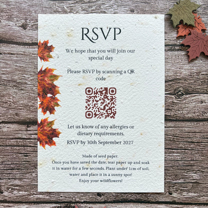 A plantable autumn wedding invite with RSVP on the back made from seed paper, styled on a rustic wooden background with autumn leaves. The card features a textured off-white paper look with printed text and a QR code.