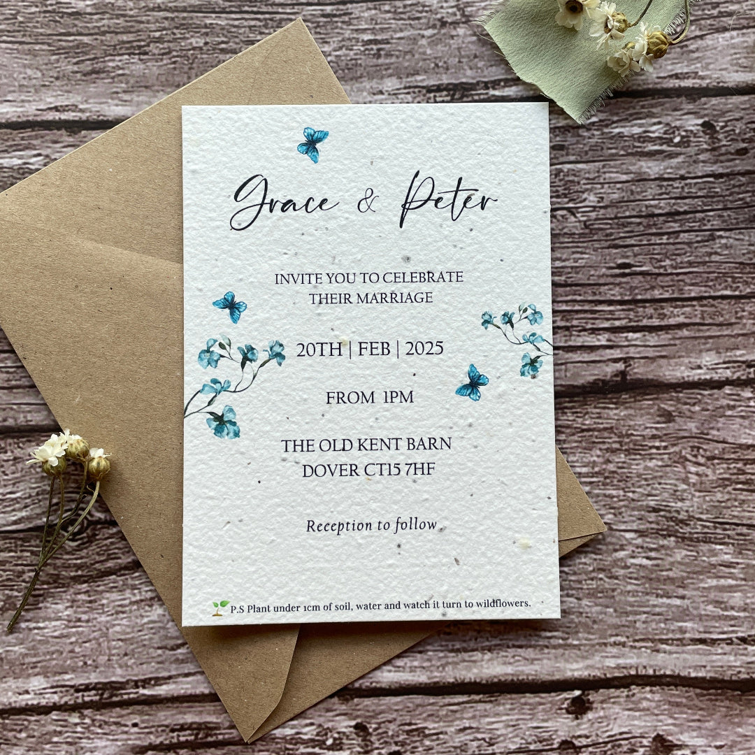 Plantable wedding invitation card with envelope on a wooden surface made of seed paper with a blue sweet pea design