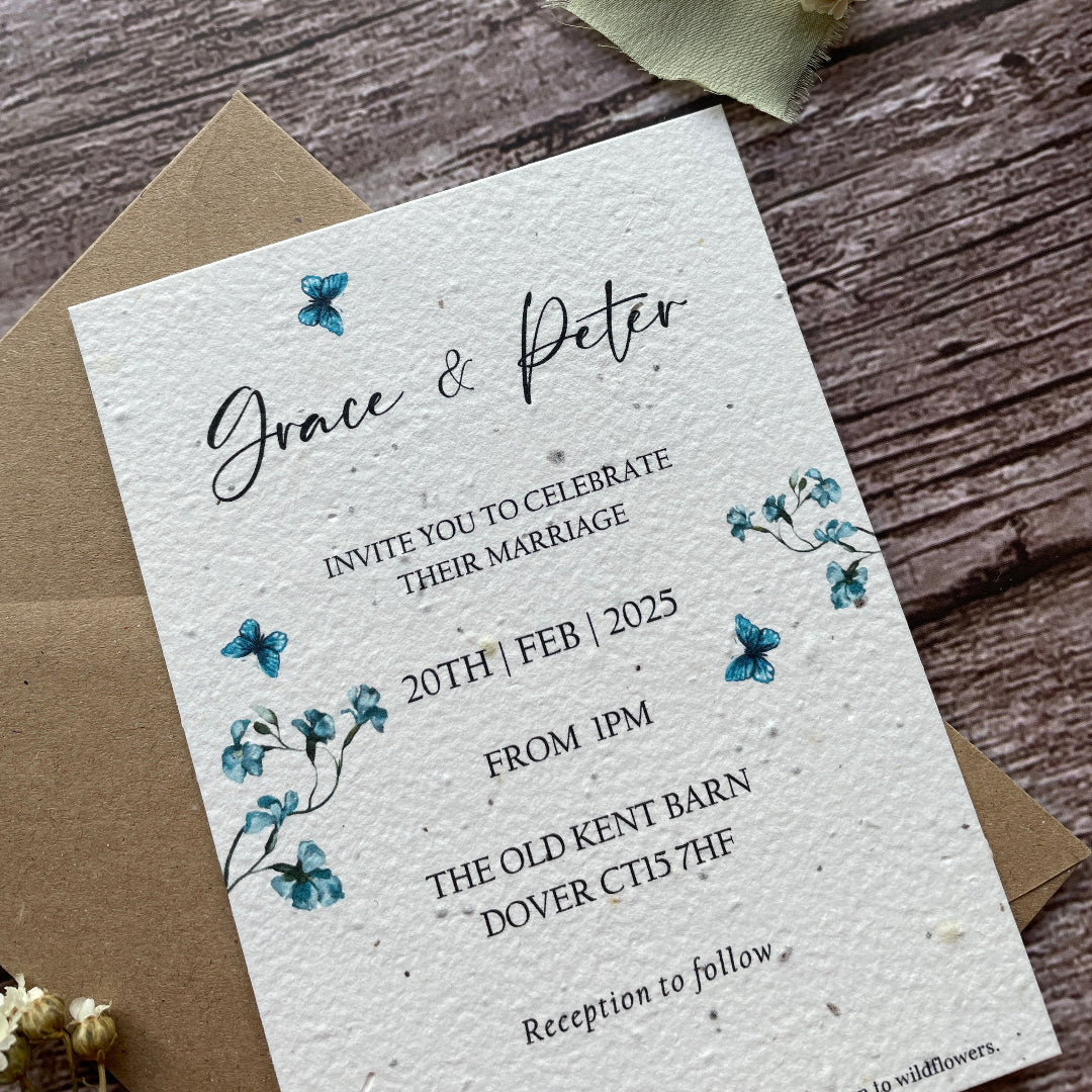 plantable seed paper wedding invites with blue sweet peas on a wooden surface