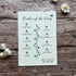 Order of the Day card on a wooden surface with flowers with blue sweet peas printed on seed paper