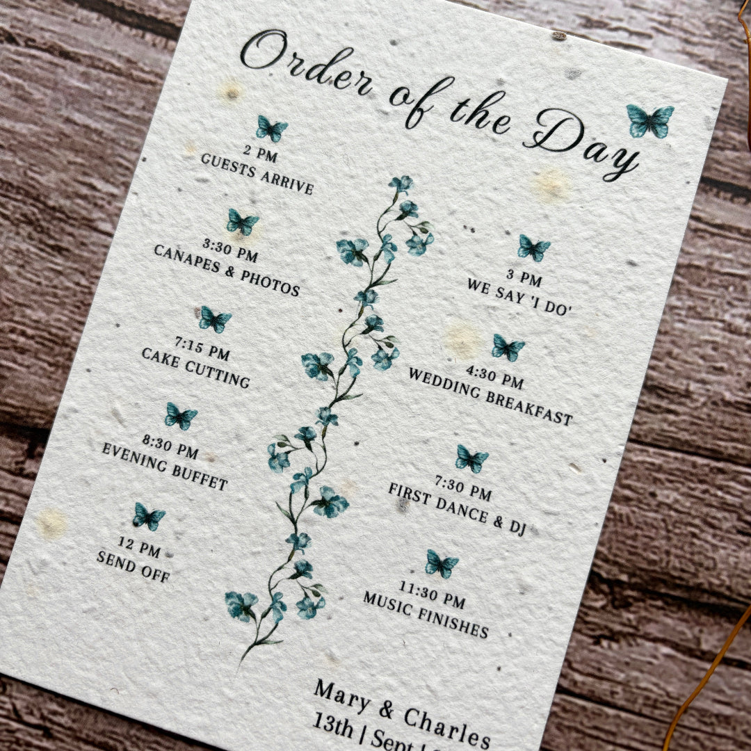 Wedding order of the day schedule with butterfly design on a wooden surface