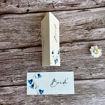 plantable seed paper wedding name cards with bluebells design on a wooden surface