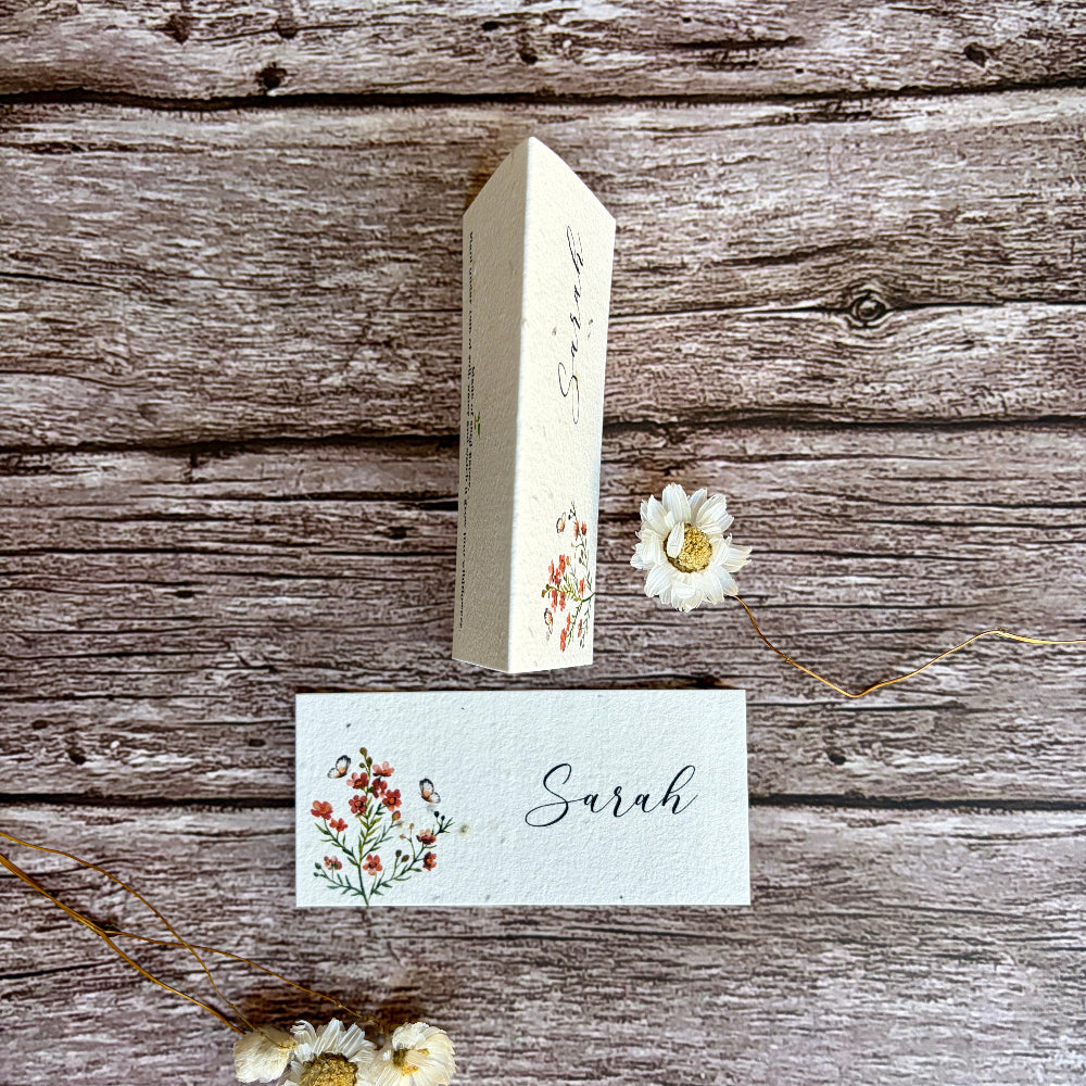 plantable wedding place cards on a wooden surface with burnt orange flowers