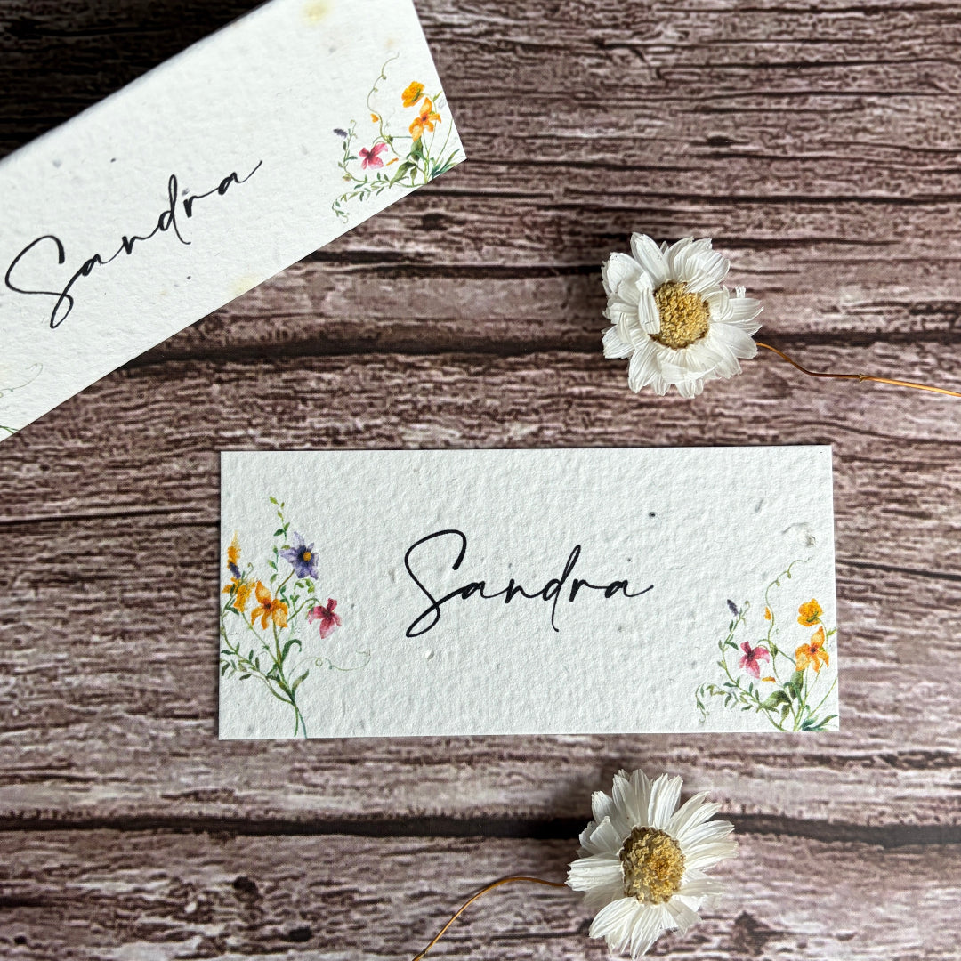 plantable wedding place cards with spring wildflowers on wooden surface