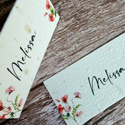 plantable seed paper name cards with sweet pea design on a wooden background