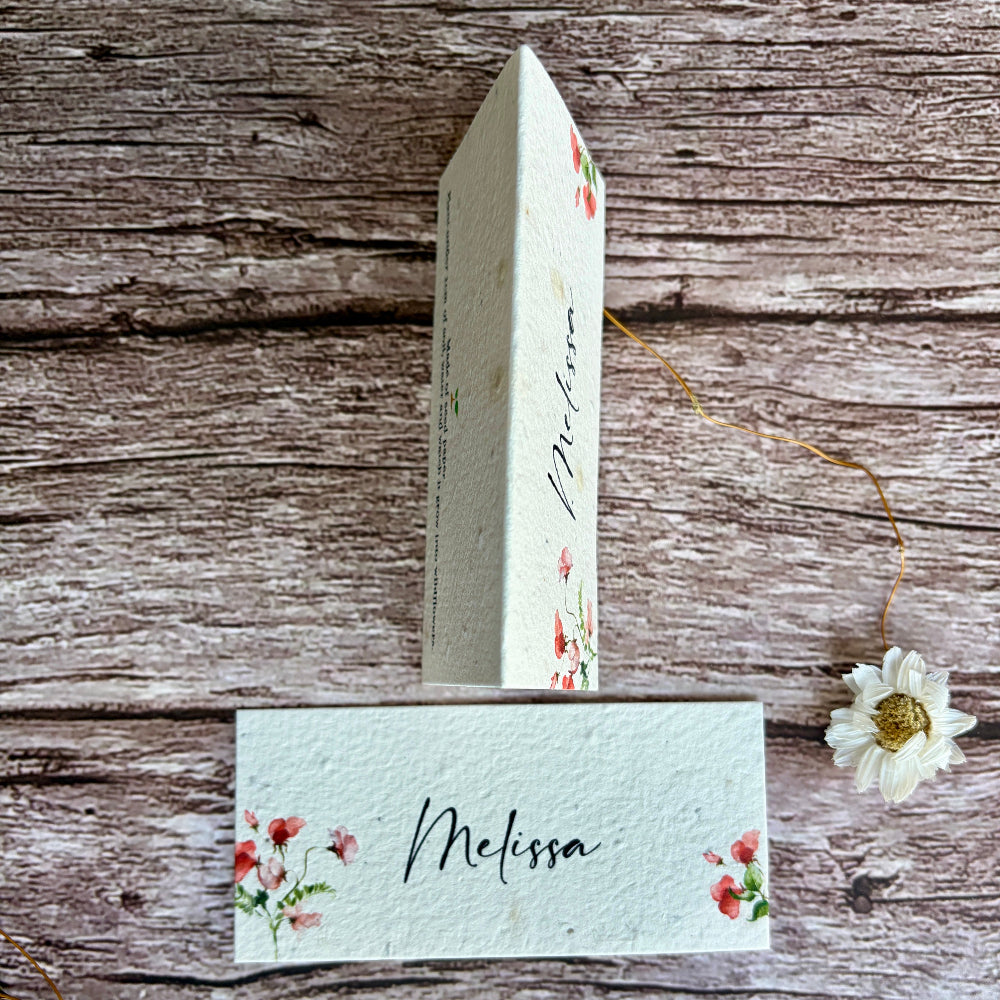 plantable wedding place cards with sweet pea design on a wooden surface