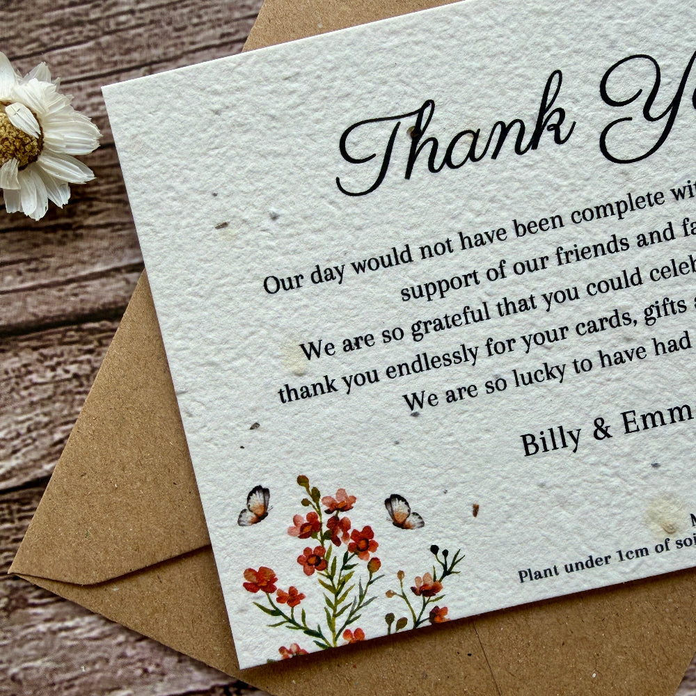 Plantable wedding Thank you card with burnt orange floral design and text on a wooden surface