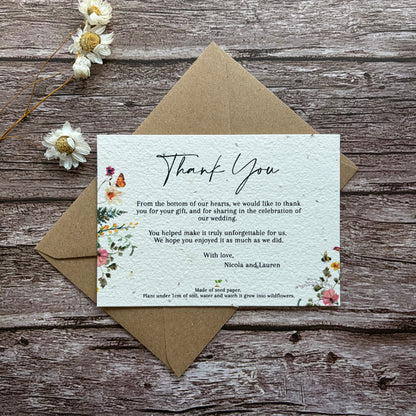 Plantable wedding thank you card with floral design and text on a wooden surface