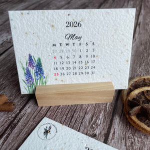 Seed paper 2026 calendar with floral design on a wooden surface on a stand