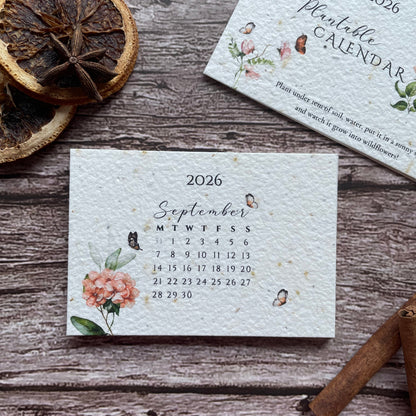 Floral-patterned 2026 plantable calendar on a wooden surface with dried oranges and cinnamon sticks.