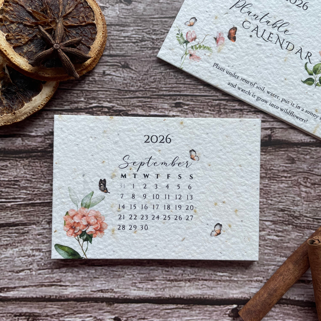Floral-patterned 2026 plantable calendar on a wooden surface with dried oranges and cinnamon sticks.
