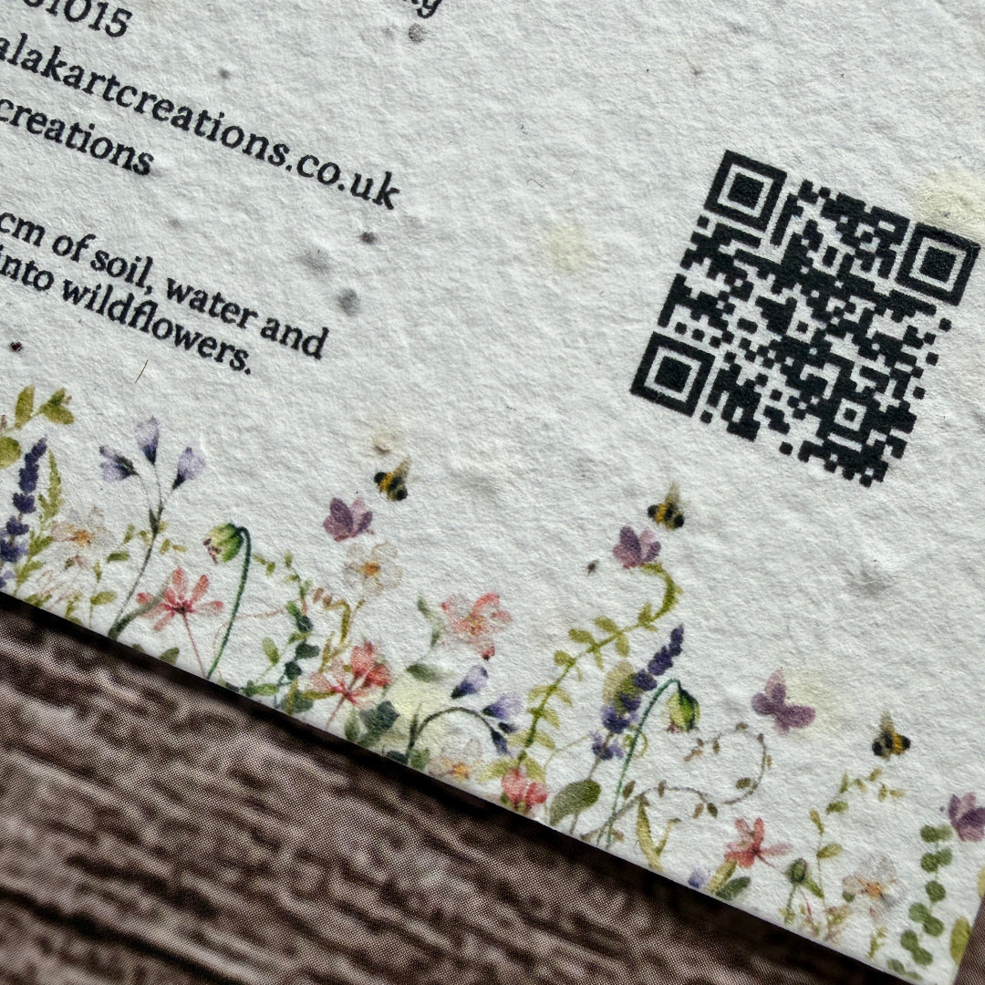 Seed paper business card on a textured paper with a QR code and text.