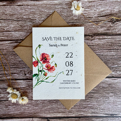 Plantable save the date card with poppies design on a wooden surface