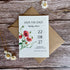 Plantable save the date card with poppies design on a wooden surface