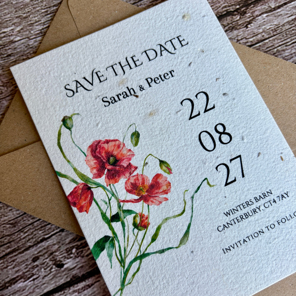 Plantable save the date card with floral design and brown envelope on wooden surface