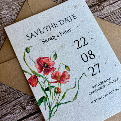 Plantable save the date card with floral design and brown envelope on wooden surface