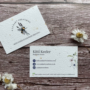 seeded business cards with dark blue logos and wildflowers, featuring eco-friendly design and sustainable branding, from a la kart creations